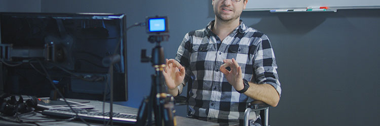 Medium shot of a man in wheelchair recording video for a vlog
