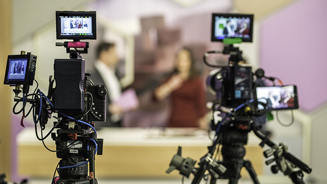Rear view of two cameras filming an infomercial TV-show.