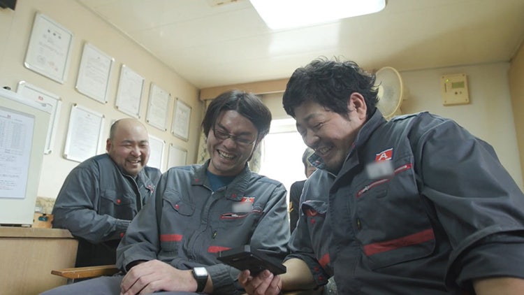 スマ－トフォンを見ながら談笑する乗組員