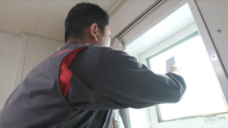 乗組員はわずかな電波をつかもうと船室の窓際でスマートフォンをかざすが、場所によっては通信ができない