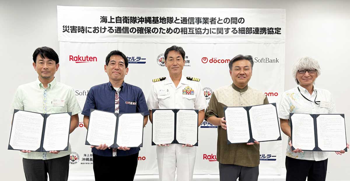 当日の写真、左から 楽天モバイル株式会社 BCP管理本部長　磯邉 直志、沖縄セルラー電話株式会社 執行役員 兼 経営管理本部長　嶺井 敏樹、海上自衛隊沖縄基地隊司令 1等海佐　渡邉 雄一、株式会社NTTドコモ 九州支社 ネットワーク部長　瀧 康宏、ソフトバンク株式会社 九州ネットワーク技術部長　菊地 健吾