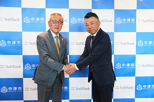 中津市長の奥塚 正典氏（左）とソフトバンクの営業第二本部 本部長の田口 貴将